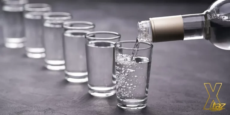 Vodka pouring from bottle into a couple of glasses